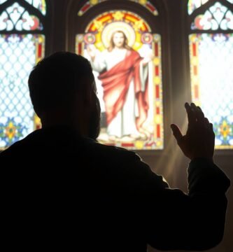 Bild des Schattens einer Person, die in einer Kirche zum Bild von Jesus betet