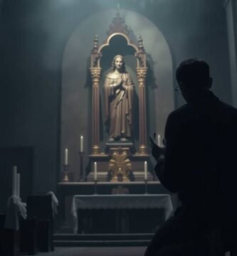 Bild des Inneren einer schwach beleuchteten Kirche mit dem Schatten eines Mannes, der dem Bild von Jesus den Rücken zukehrt und betet.