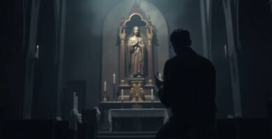 Bild des Inneren einer schwach beleuchteten Kirche mit dem Schatten eines Mannes, der dem Bild von Jesus den Rücken zukehrt und betet.