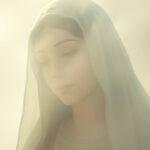 Nahaufnahme des Gesichts der Jungfrau Maria, das von einem Schleier bedeckt ist, mit einem göttlichen, schwachen Licht, das das gesamte Bild erhellt, und einem grau-weiß beleuchteten Hintergrund