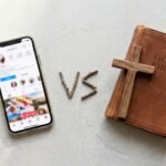 Abbildung eines Mobiltelefons mit Social-Media-App an der Seite, daneben eine Bibel und ein Kreuz.