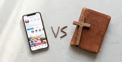 Abbildung eines Mobiltelefons mit Social-Media-App an der Seite, daneben eine Bibel und ein Kreuz.